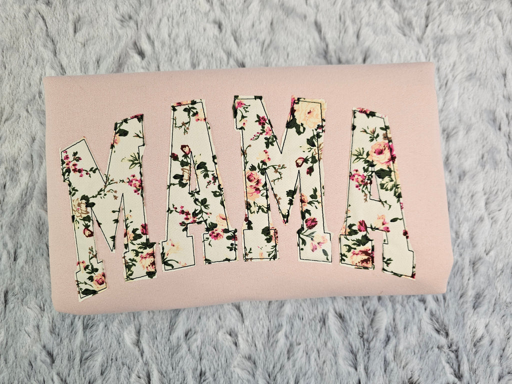 crew neck embroidered with a floral applique.