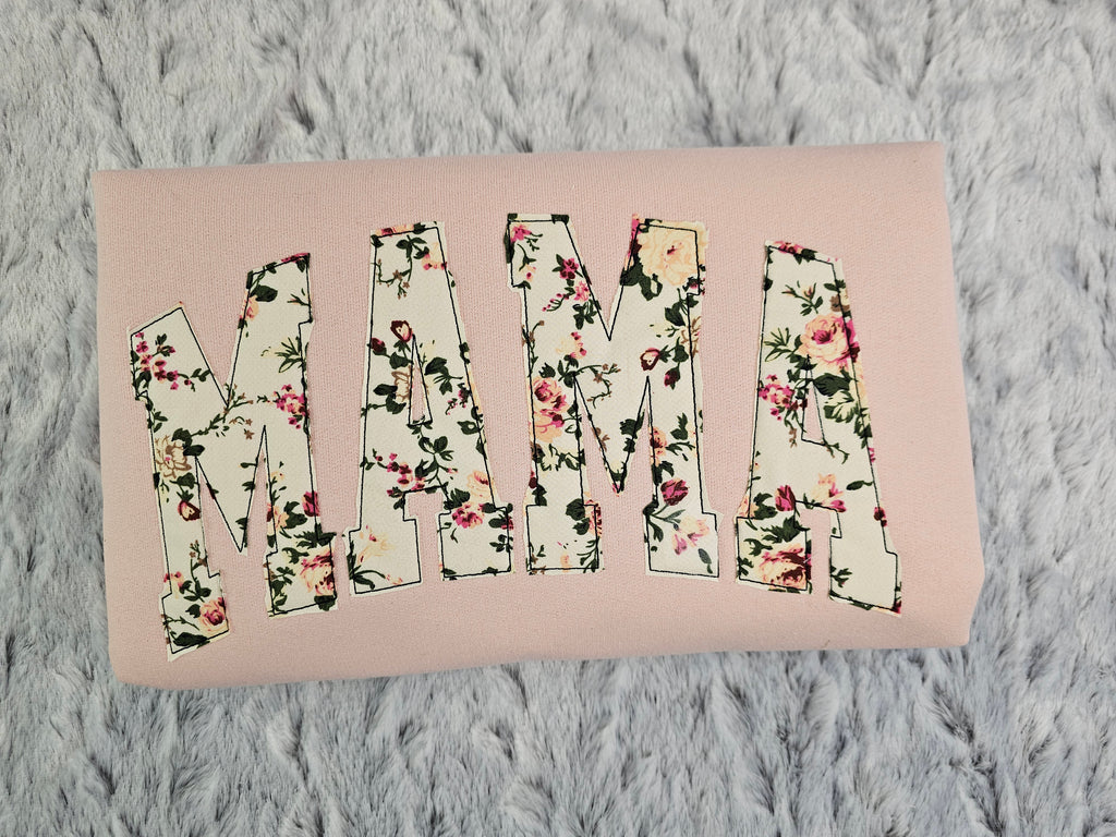 crew neck embroidered with a floral applique.