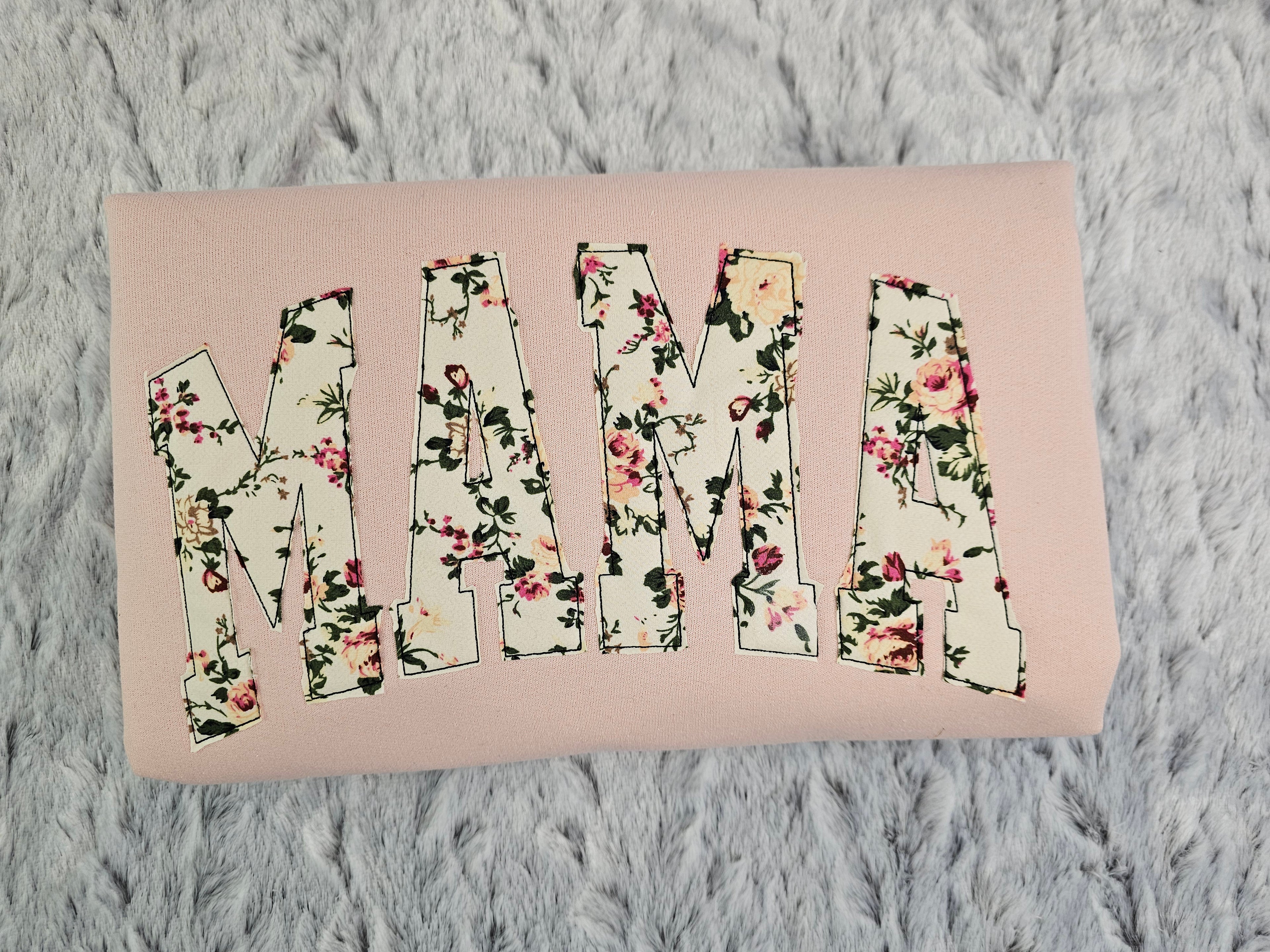 crew neck embroidered with a floral applique.