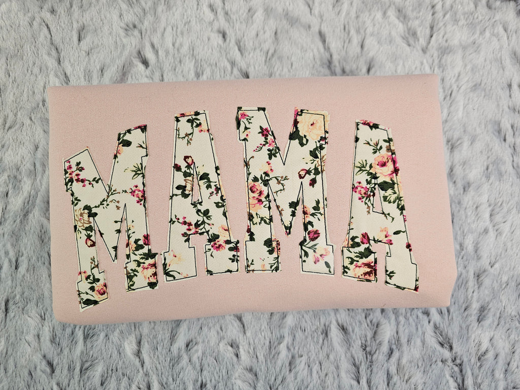 crew neck embroidered with a floral applique.