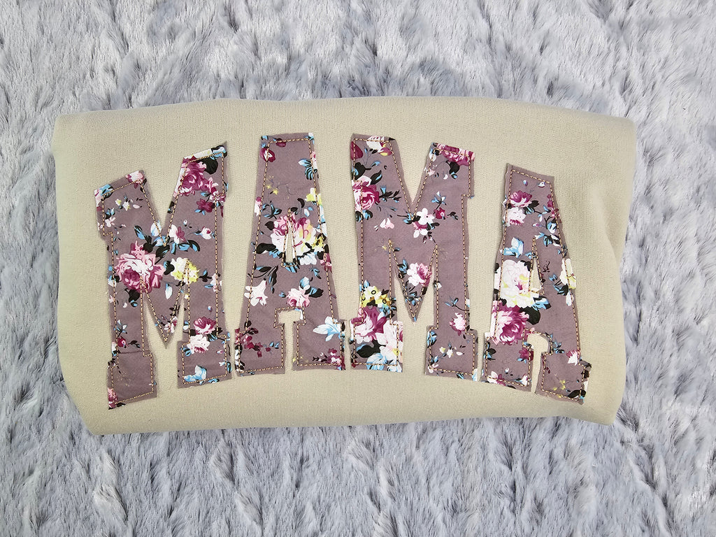 crew neck embroidered with a floral applique.