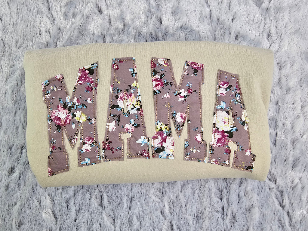 crew neck embroidered with a floral applique.